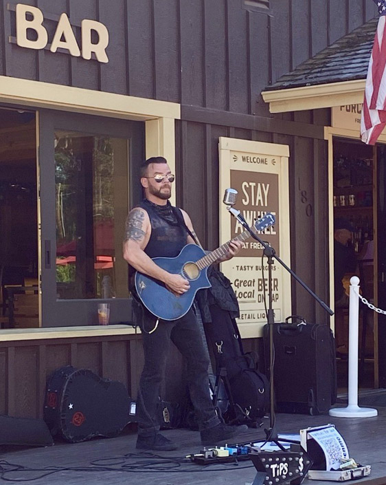 A person standing on stage playing guitar.