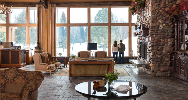 Two people looking out the window in the lobby at Grouse Mountain Lodge.