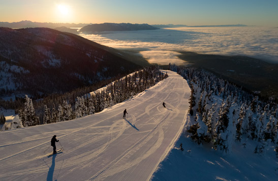 An aerial view of three people skiing down a mountain.