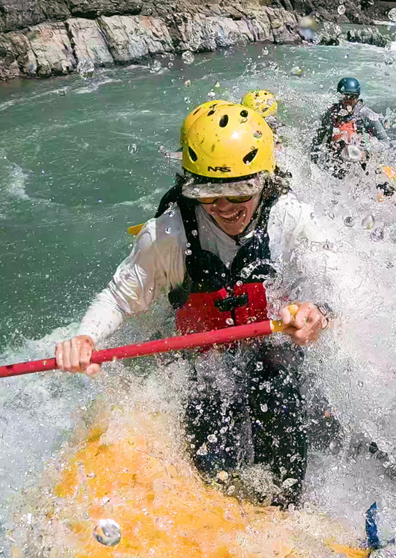A head-on view of a rafting group paddling through rapids along the Flathead River in Montana.