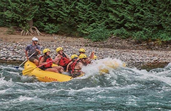 Rafters with a guide standing on the back of the boat.