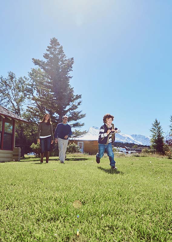 A family walking on a green lawn.