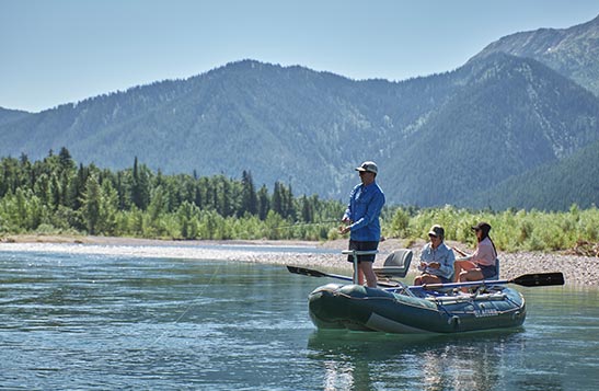 A man and two women on a boat fishing.