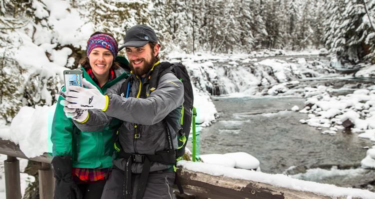 A couple taking a selfie on a hiking trail beside the river